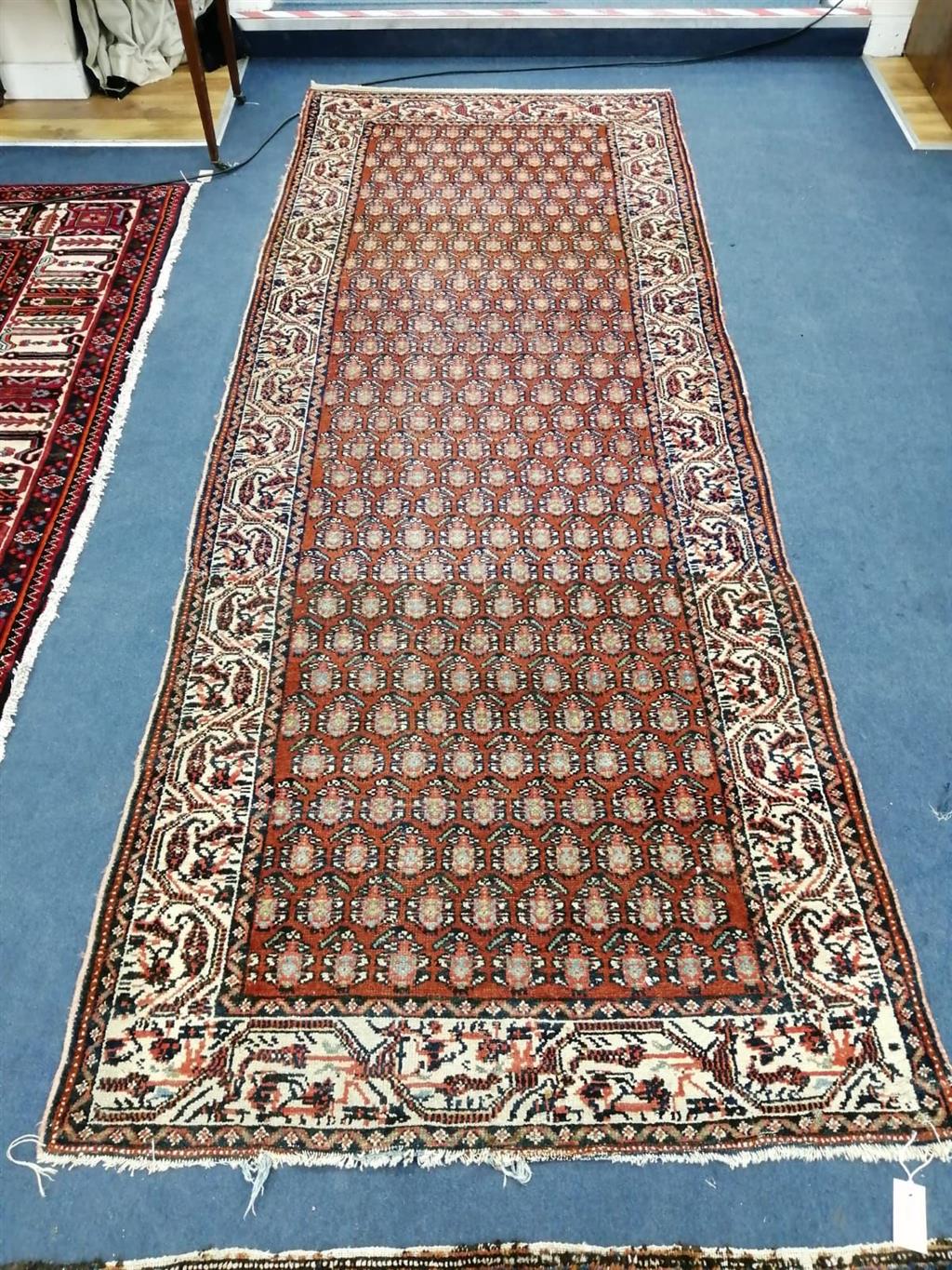 A Persian red ground runner, 290 x 110cm